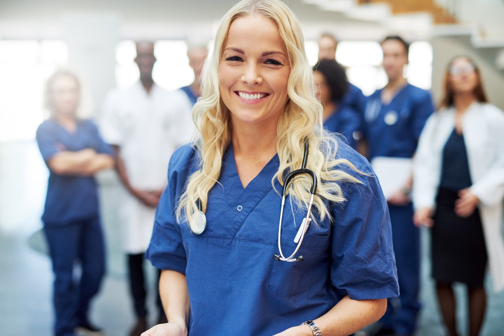 Smiling blond doctor with stethoscope in hospital